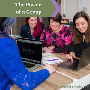 Four women gather around a laptop to signify the power of a group experience.  