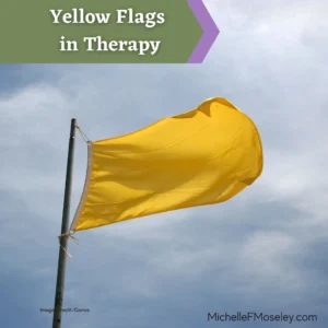 A yellow flag is waving in the wind with a partly cloudy sky in the background.