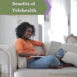 A woman with brown skin and shoulder length, curly black hair sits cross legged on a couch with a laptop on her lap as she attends therapy via telehealth.  