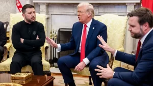 Ukranian President Zelensky sits with arms crossed as US President Trump and US Vice President Vance speak over him.  