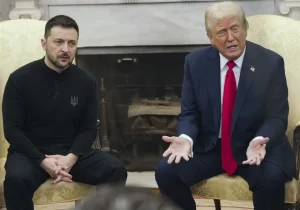 Ukrainian President Zelensky sits with arm dropped and a look of defeat while US President Trump continues to speak.  