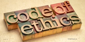 Wooden blocks with letters on them are lined up to write out "code of ethics."