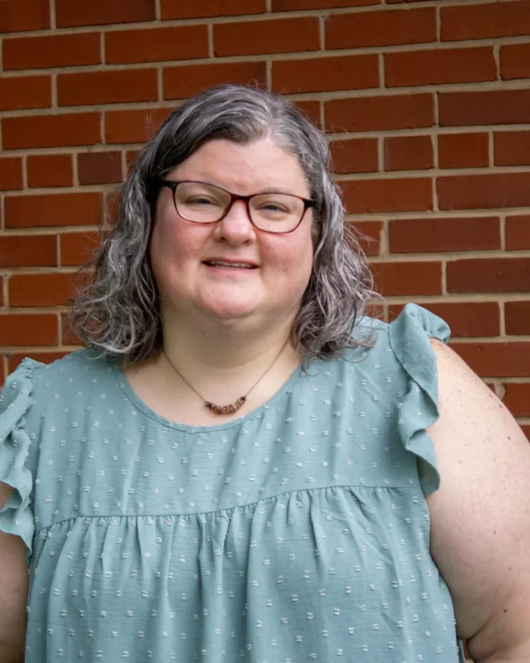 Image of Michelle F. Moseley, LCMHC - a fat, white woman with shoulder length brown-grey hair, wearing eyeglasses and a pale green shirt.