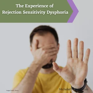 A white man with short brown hair and wearing a yellow shirt has one hand covering his face and the other held with palm out as though pushing someone away.  This represents the experience of rejection sensitive dysphoria - wanting to hide and push others away in order to avoid the pain of rejection.  